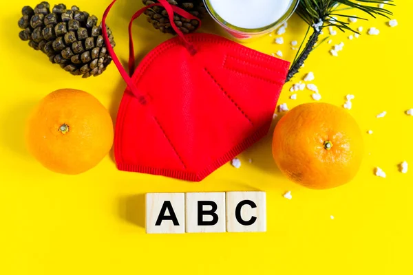 Mandalinalar tıbbi maskenin içinde Noel ağacının dalları arasında yatar.