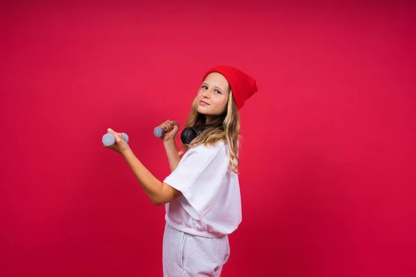 Mädchen Macht Fitnessübungen Mit Kurzhanteln Auf Rotem Hintergrund — Stockfoto