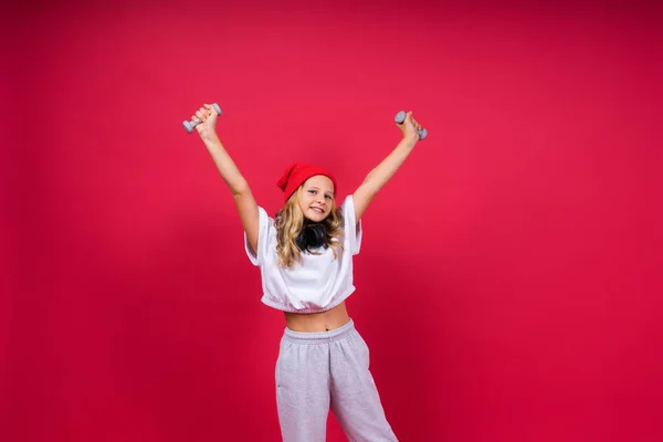 Mädchen Macht Fitnessübungen Mit Kurzhanteln Auf Rotem Hintergrund — Stockfoto
