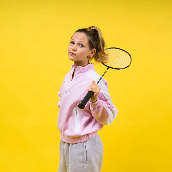 フル長いスタジオ写真10歳の女の子を保持していますバドミントンラケットと黄色に分離 — ストック写真