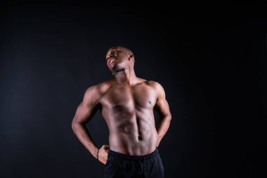 Portrait of athletic african american man topless, black background