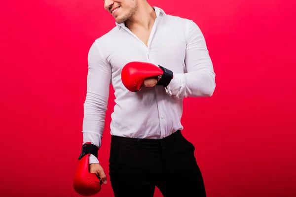 ボクシングの手袋でハンサムな若いビジネスマン スタジオレッドの背景 — ストック写真