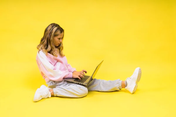 stock image Little blonde kid girl on a pastel yellow wall background. Childhood lifestyle concept.