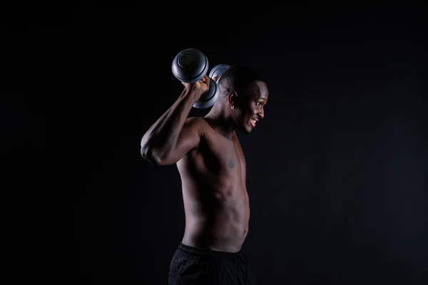 Uomo Muscoloso Africano Isolato Con Manubri Uno Sfondo Scuro Studio — Foto Stock