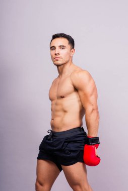 Stüdyoda izole edilmiş kırmızı eldivenli profesyonel boksör. Spor, yarışma konsepti.