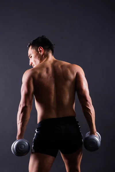 赤身裸体的健美运动员举着哑铃 展示着他伟大的身躯 — 图库照片