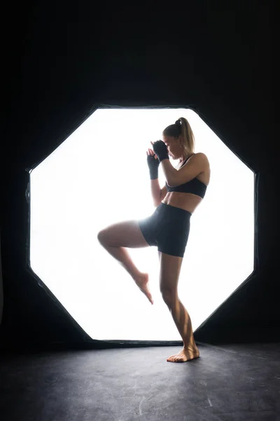 黄色の背景で手袋のトレーニングで女性ボクサー — ストック写真