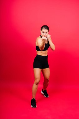 Woman Boxer In Gloves Training On a black, red, yellow Background