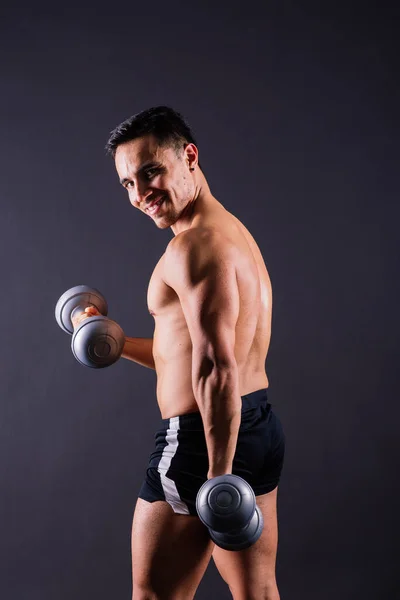 赤身裸体的健美运动员举着哑铃 展示着他伟大的身躯 — 图库照片