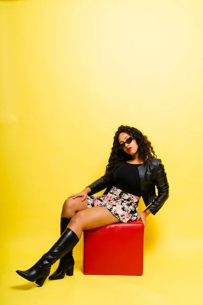 stock image Seductive african woman posing in a black bodysuit and jacket in studio. Fit sporty female.