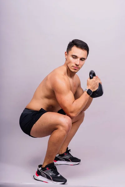 英俊的肌肉男拿着一个有复制空间的水壶铃 西班牙男子运动员 — 图库照片