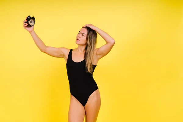Weibchen Halten Wecker Isoliert Auf Gelb Junges Modell Schwarzen Badeanzug — Stockfoto