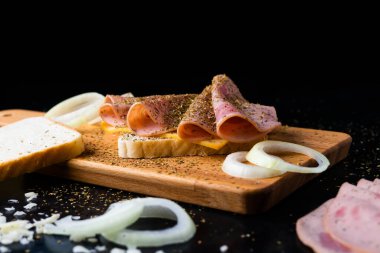 Slices of sausage Mortadella and onion on a cutting board