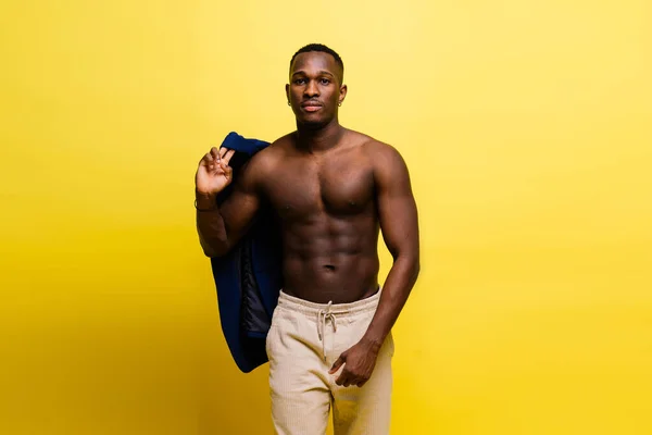 stock image Portrait of athletic african american man topless smiling, yellow, red and black background