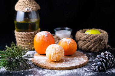 Yılbaşı Noel 'inde, siyah arka planda mandalina konilerinin yanındaki çam ağacının hayat dalı