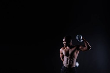 Afrikalı Amerikalı yakışıklı vücut geliştiricinin yakın plan kasları, çıplak gövde, siyah stüdyo geçmişi.