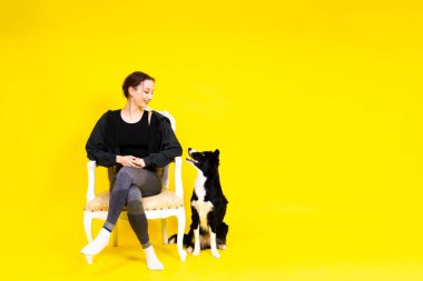 Beyaz bir kadın bir çoban köpeğini eğitiyor. İnsan ve hayvan arasındaki ilişki kavramı.