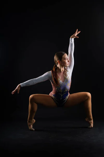 Portrait of a beautiful young woman gymnast training calilisthenics exercise with acrobatic element