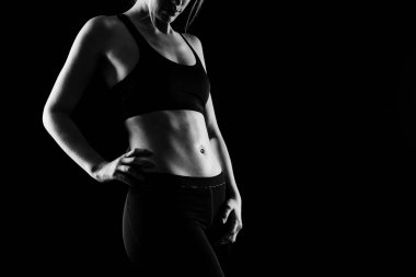 Spor üniforması giymiş, stüdyoda poz veren güzel bir genç kadın. Sağlıklı yaşam tarzı, spor