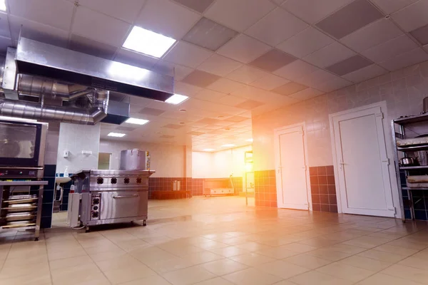 Industrial kitchen in school restaurant with professional equipment and pans