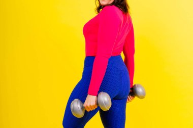 Dambılı, kıvrımlı bir vücudu olan sportif bir model. Dinamik hareket. Motivasyon ve sağlıklı yaşam tarzı