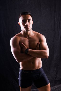 Güzel erkek gövdesi, kaslı vücut geliştirici pozu. Bir sporcunun baştan çıkarıcı portresi.