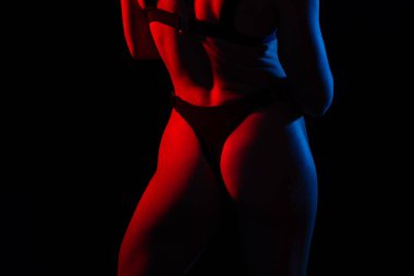Seductive young beautiful ass in a thong black underwear, dark background.