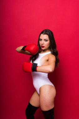 Vücut ve eldiven giymiş baştan çıkarıcı kadın boksörün stüdyo portresi.