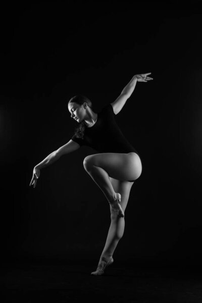 Gymnastics, woman acrobat, female gymnast strong flexible body over black and white backgrounds