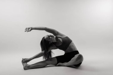 Güzel bir kadın yoga sınıfında Padmasana Lotusu ya da Kamalasana pozu veriyor. Stüdyo çekimi.