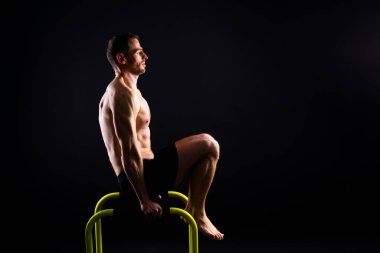 Erkek jimnastikçi paralel barlarda amuda kalkıyor.