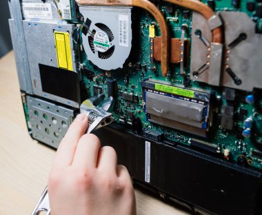 Servis mühendisi dizüstü bilgisayara yeni çipler yükle. Dizüstü bilgisayar tamiri ve güncellemesi. Kapat..