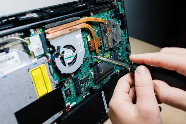 Servis mühendisi dizüstü bilgisayara yeni çipler yükle. Dizüstü bilgisayar tamiri ve güncellemesi. Kapat..