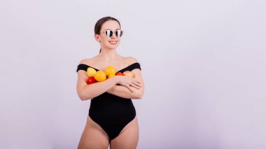 Elma, limon, portakal tutan bir dişi gri arka planda izole edilmiş farklı kollarda..