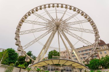 Büyük, uzun, beyaz dönme dolap, kusursuz mavi gökyüzünün önünde. Mutlu yaz tatili duyguları.