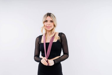 Beyaz bir arka planda direniş bandıyla çalışan genç bir kadın. Kuvvet ve motivasyon.
