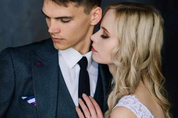 stock image Cute wedding couple in the interior of a classic studio. They kiss and hug each other.