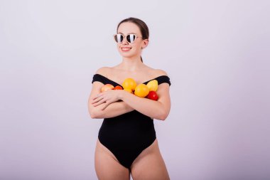 Elma, limon, portakal tutan bir dişi gri arka planda izole edilmiş farklı kollarda..