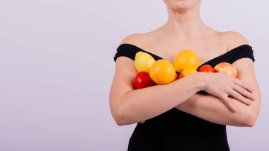 Elma, limon, portakal tutan bir dişi gri arka planda izole edilmiş farklı kollarda..