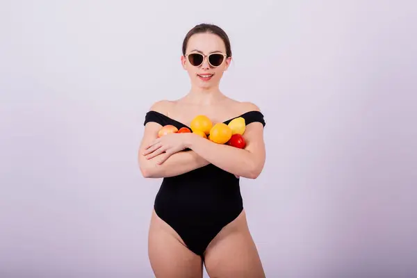 橙子在灰色背景下分开的不同臂膀中抱着苹果 橙子的女性 — 图库照片