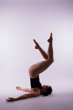 Stüdyo arka planında poz veren güzel yoga kadını.