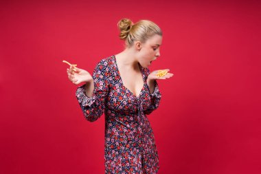 Genç ve narin bir bayan patates kızartması yiyor. Sağlıksız şişman abur cubur ve sağlıklı yemek kavramı