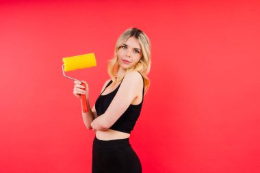 Genç zihniyetli işçi işçi kadın paten fırçası boyası seçiyor.