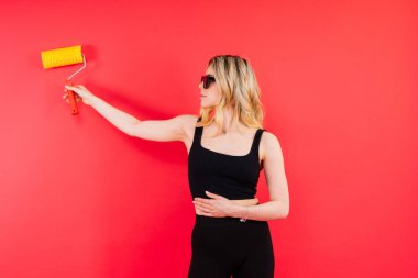 Heyecanlı bir bayan müteahhit. Boyama fırçası veya boya silindirli bir ressam.