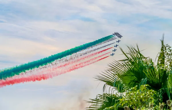 stock image Air show of the Frecce Tricolori aerobatic team of the Italian Air Force with colored smoke trails in front of partly clouded sky