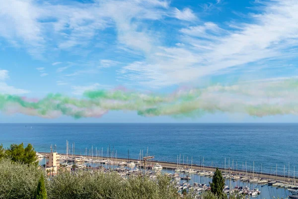 Coastal scenery with colorful fume trails of an air show seen in Liguria, Italy