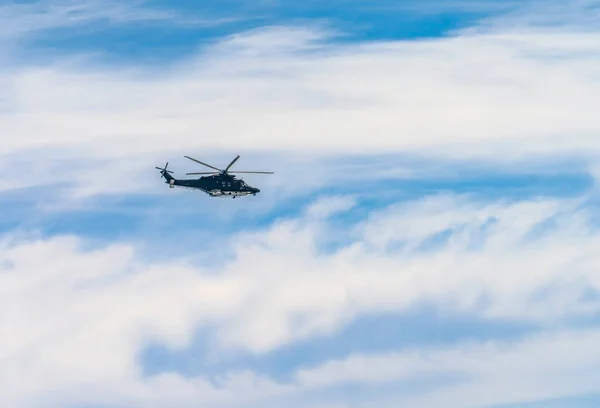 直升机带着一些云彩在天空中飞行 — 图库照片