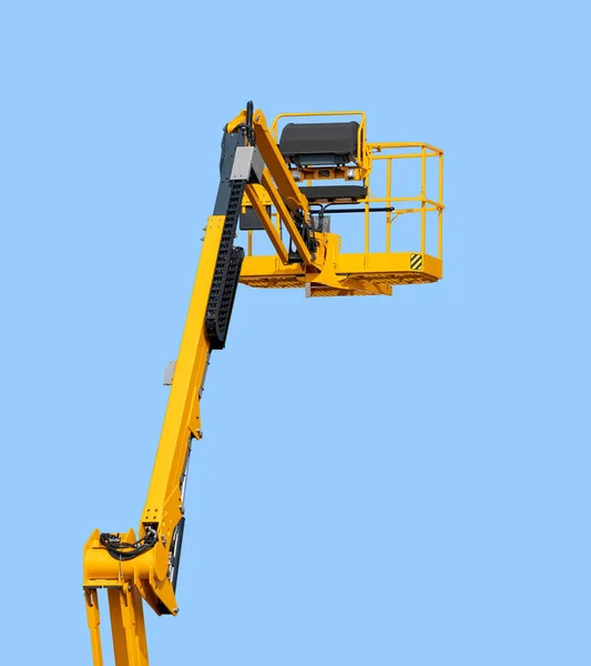 Yellow aerial work platform in front of blue sky