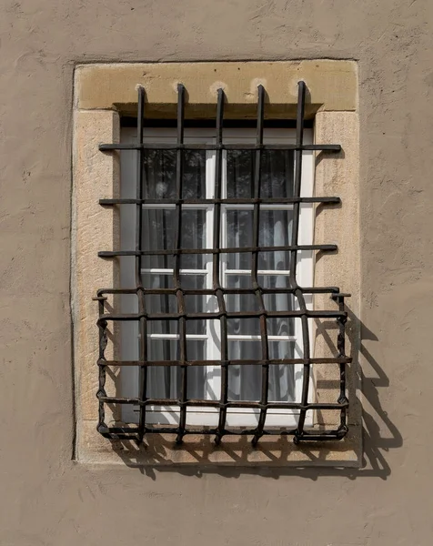 Slunečné Osvětlené Zamřížované Okno Omítnuté Stěně — Stock fotografie