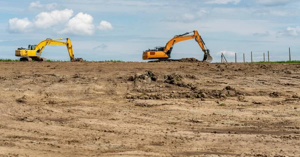 地上的地平线上有两台挖掘机 — 图库照片